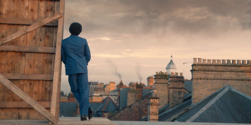 Le Docteur regarde l'horizon de Londres du haut du toit
